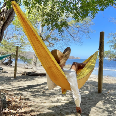Person in a hammock in front of the ocean