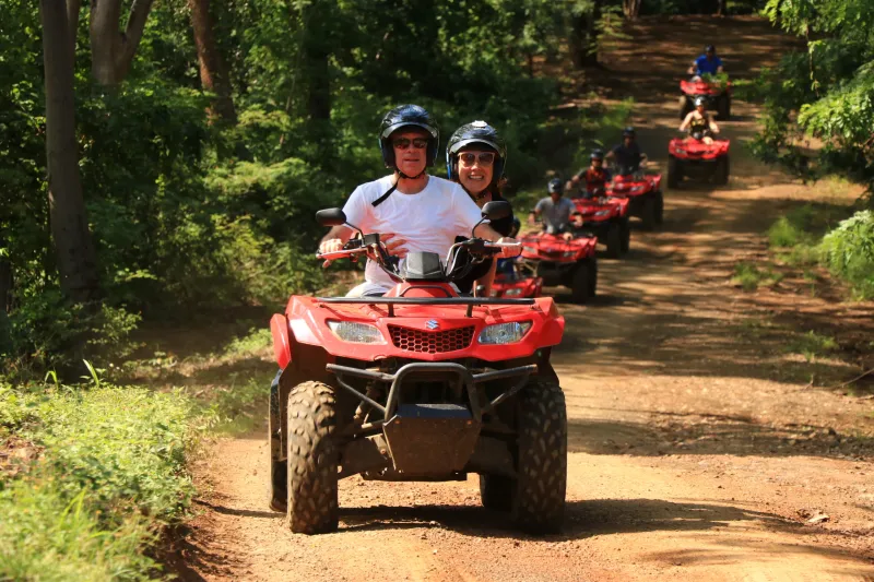 a man riding a motorcycle down a dirt road